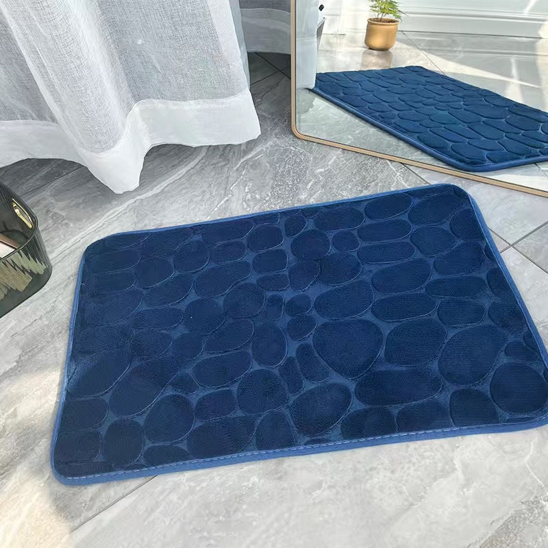 Blue textured bath mat on a bathroom floor 