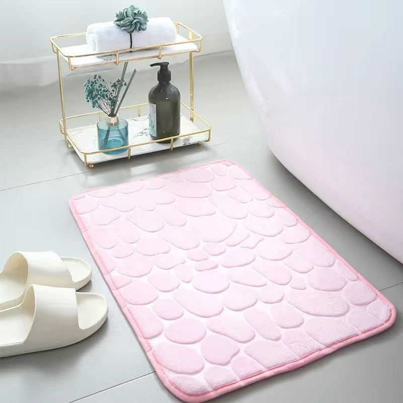Pink bath mat on a bathroom floor