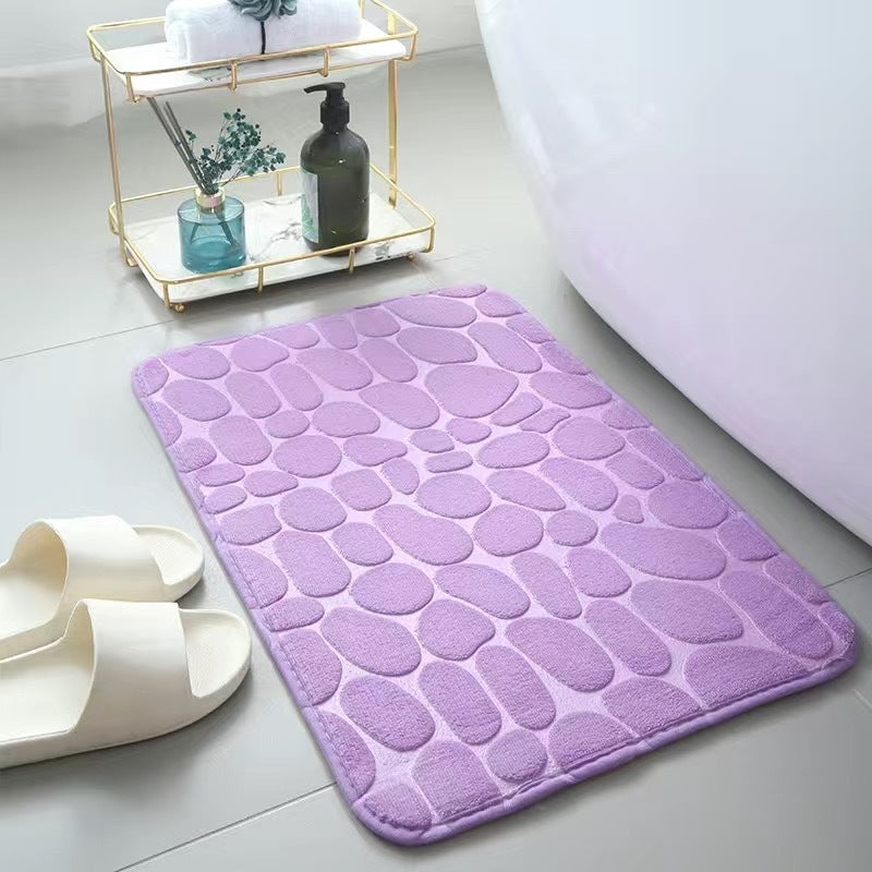 Purple textured bath mat on a bathroom floor 