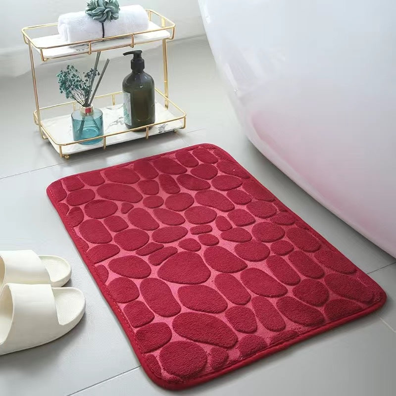 Red textured bath mat on a bathroom floor