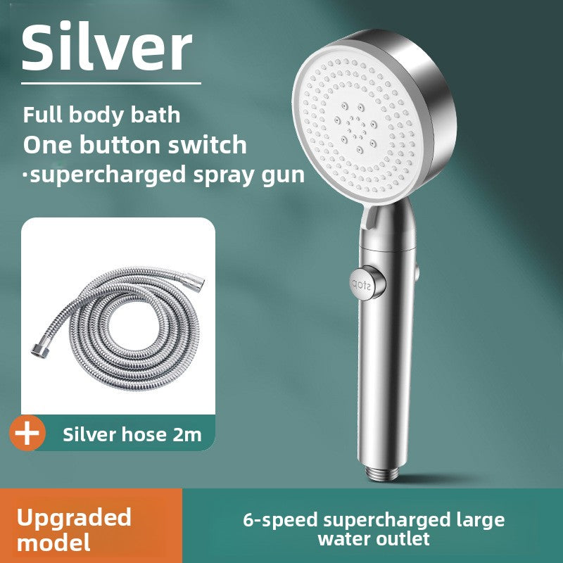Silver handheld shower head with hose on a green background